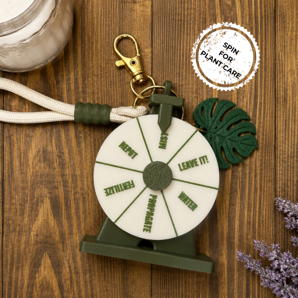 Wheel for plant care on a wooden surface with a keychain and leaf decorations.
